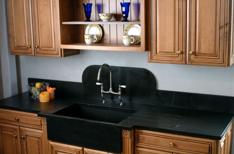 Inspiration for a mid-sized single-wall kitchen remodel in Boston with a farmhouse sink, raised-panel cabinets, medium tone wood cabinets and quartz countertops
