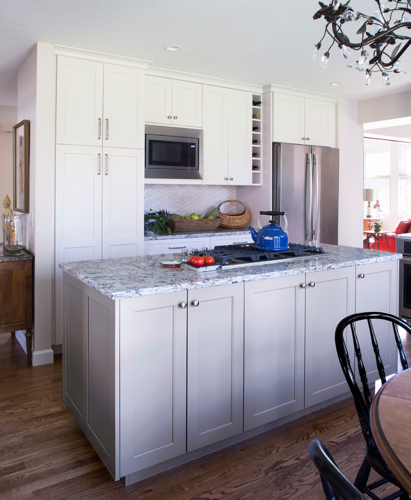 Small transitional l-shaped medium tone wood floor eat-in kitchen photo in Denver with shaker cabinets, gray cabinets, quartz countertops, white backsplash, glass tile backsplash, stainless steel appliances, an island and gray countertops