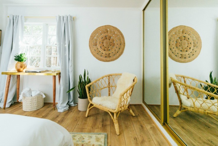 This is an example of a small midcentury guest bedroom in San Diego with white walls, laminate floors and brown floor.