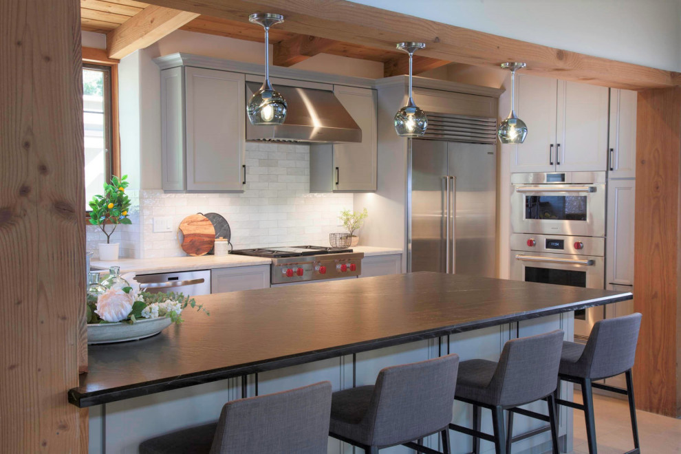 Open concept kitchen - large rustic galley porcelain tile, gray floor and wood ceiling open concept kitchen idea in Denver with an undermount sink, recessed-panel cabinets, gray cabinets, quartzite countertops, white backsplash, cement tile backsplash, stainless steel appliances, an island and white countertops