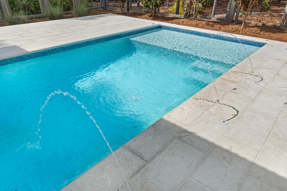 Inspiration for a small modern backyard rectangular pool in Miami with concrete pavers.