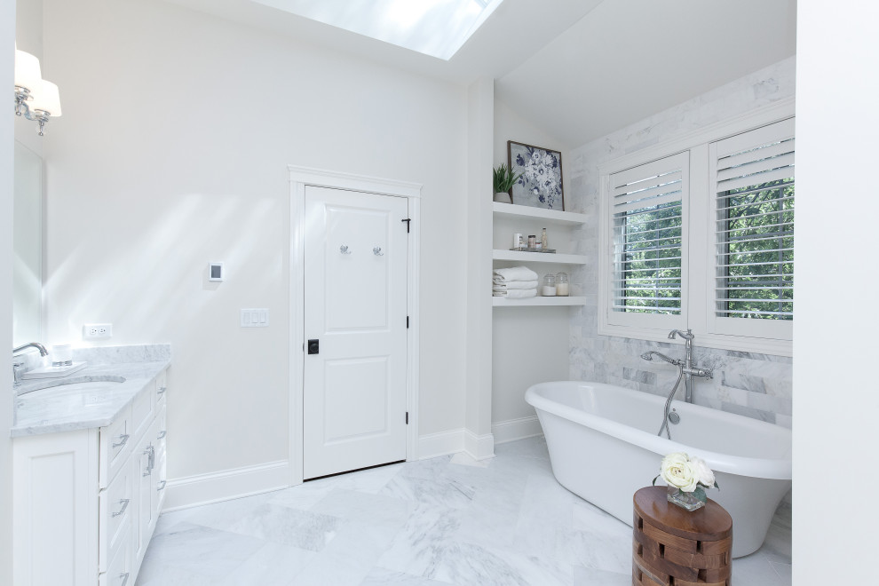 Example of a minimalist master gray tile ceramic tile, white floor and double-sink freestanding bathtub design in Chicago with white cabinets, white walls, quartzite countertops, white countertops and a built-in vanity