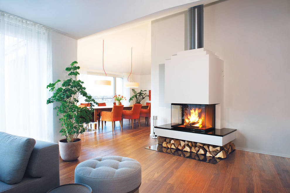 Design ideas for a mid-sized contemporary family room in Munich with white walls, dark hardwood floors, a plaster fireplace surround and a corner fireplace.