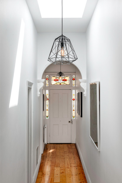 Inspiration for a small contemporary hallway in Melbourne with white walls and medium hardwood floors.