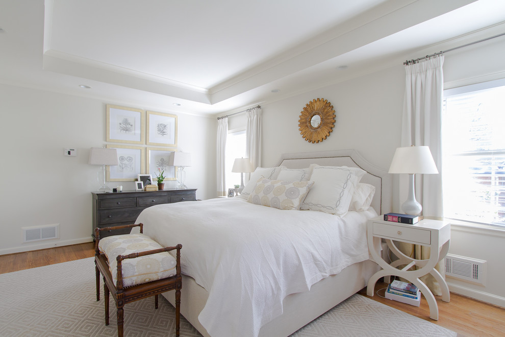 Photo of a traditional bedroom in Atlanta with white walls and light hardwood floors.