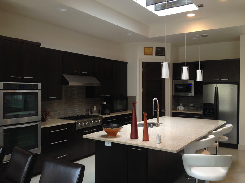 Example of a transitional u-shaped kitchen pantry design in Austin with flat-panel cabinets, dark wood cabinets, beige backsplash, stainless steel appliances and no island