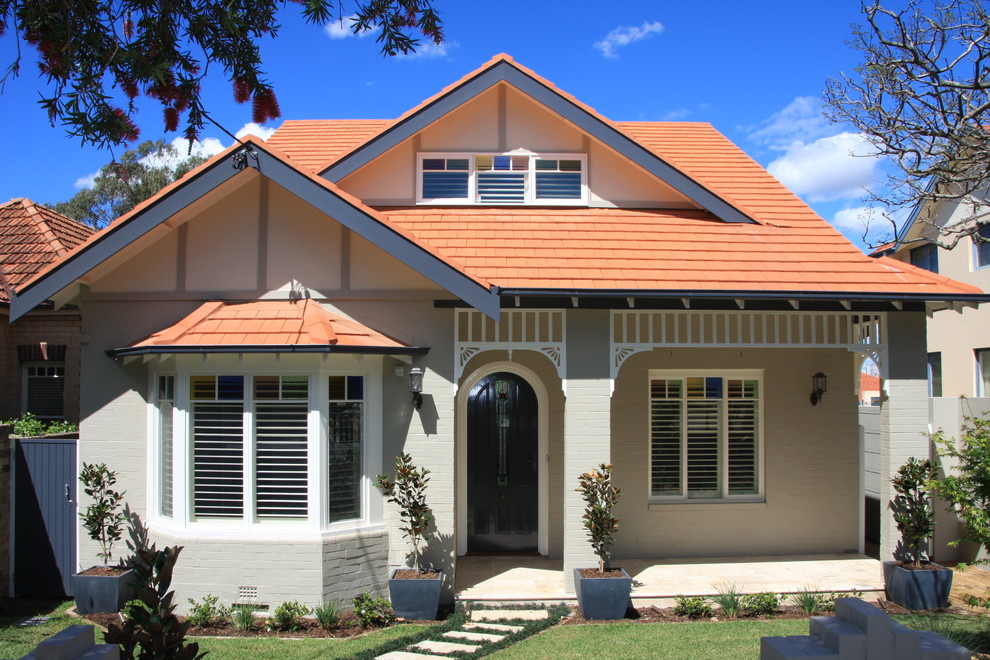 Mid-sized traditional two-storey brick white house exterior in Sunshine Coast with a gable roof and a tile roof.