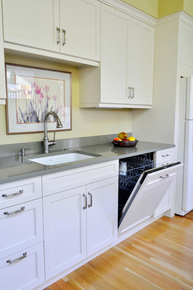 Inspiration for a mid-sized transitional light wood floor enclosed kitchen remodel in Seattle with an undermount sink, recessed-panel cabinets, white cabinets, quartz countertops, colored appliances and a peninsula