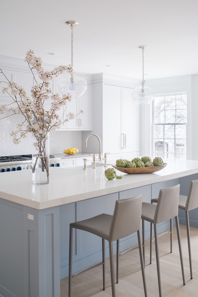 Example of a large transitional single-wall laminate floor and beige floor eat-in kitchen design in DC Metro with a farmhouse sink, flat-panel cabinets, blue cabinets, quartz countertops, white backsplash, mosaic tile backsplash, stainless steel appliances, an island and gray countertops