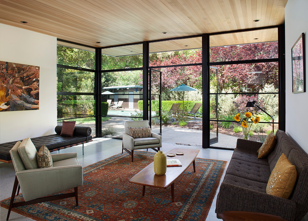 Inspiration for a midcentury formal enclosed living room in San Francisco with white walls, concrete floors, no fireplace and no tv.