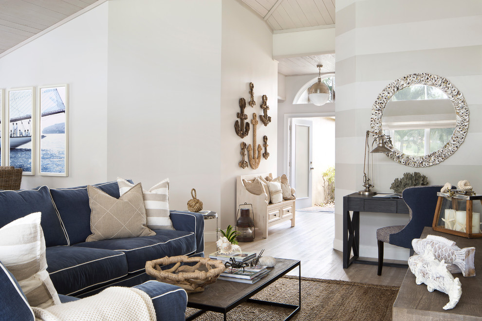Inspiration for a mid-sized beach style open concept living room in Miami with white walls, light hardwood floors, no fireplace and a wall-mounted tv.