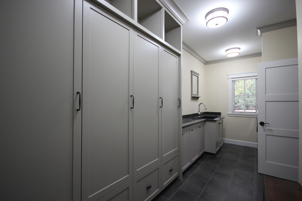 Large traditional single-wall utility room in Vancouver with a drop-in sink, shaker cabinets, grey cabinets, granite benchtops, porcelain floors, a side-by-side washer and dryer and beige walls.