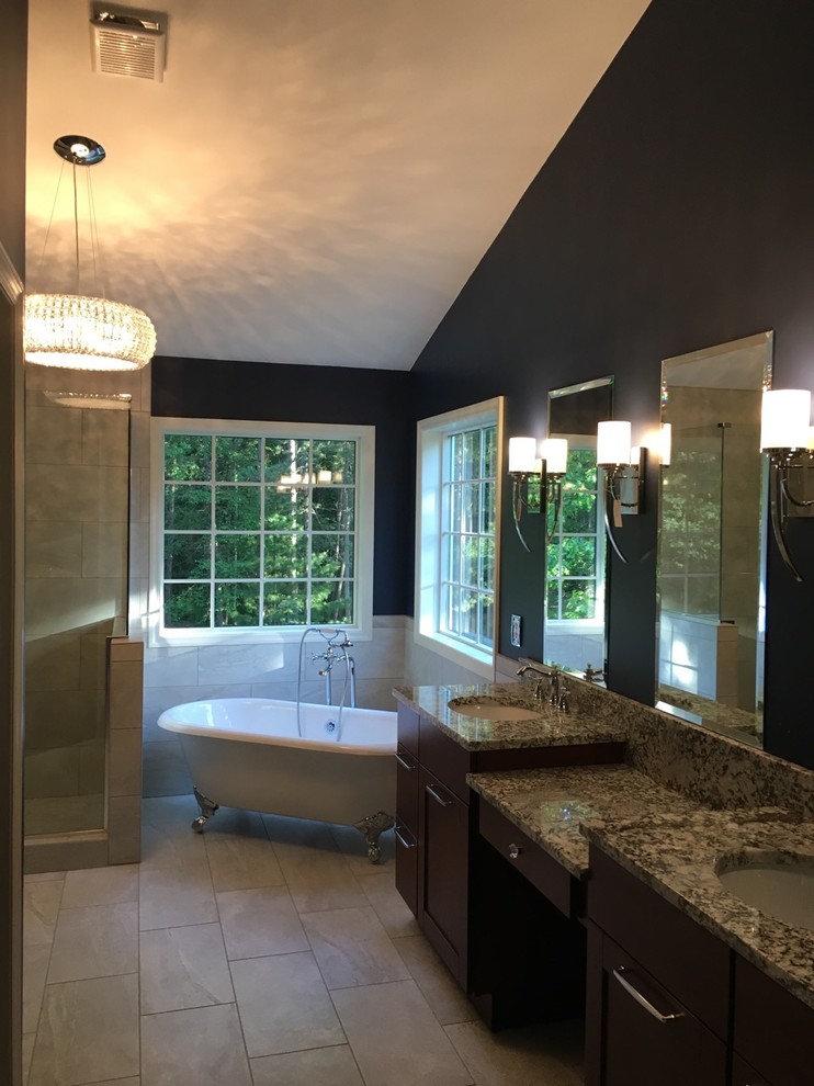 This is an example of a large transitional master bathroom in New York with shaker cabinets, dark wood cabinets, a claw-foot tub, a corner shower, beige tile, an undermount sink, granite benchtops, beige floor, a hinged shower door, ceramic tile, blue walls and ceramic floors.