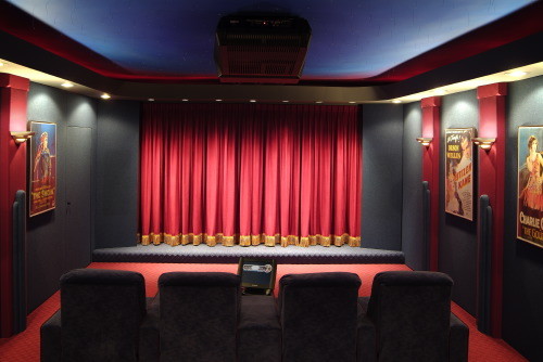 Inspiration for a mid-sized traditional enclosed home theatre in Other with black walls, carpet and a projector screen.