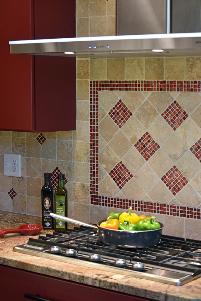Inspiration for a large transitional porcelain tile and beige floor enclosed kitchen remodel with an undermount sink, flat-panel cabinets, red cabinets, granite countertops, beige backsplash, travertine backsplash, stainless steel appliances and an island