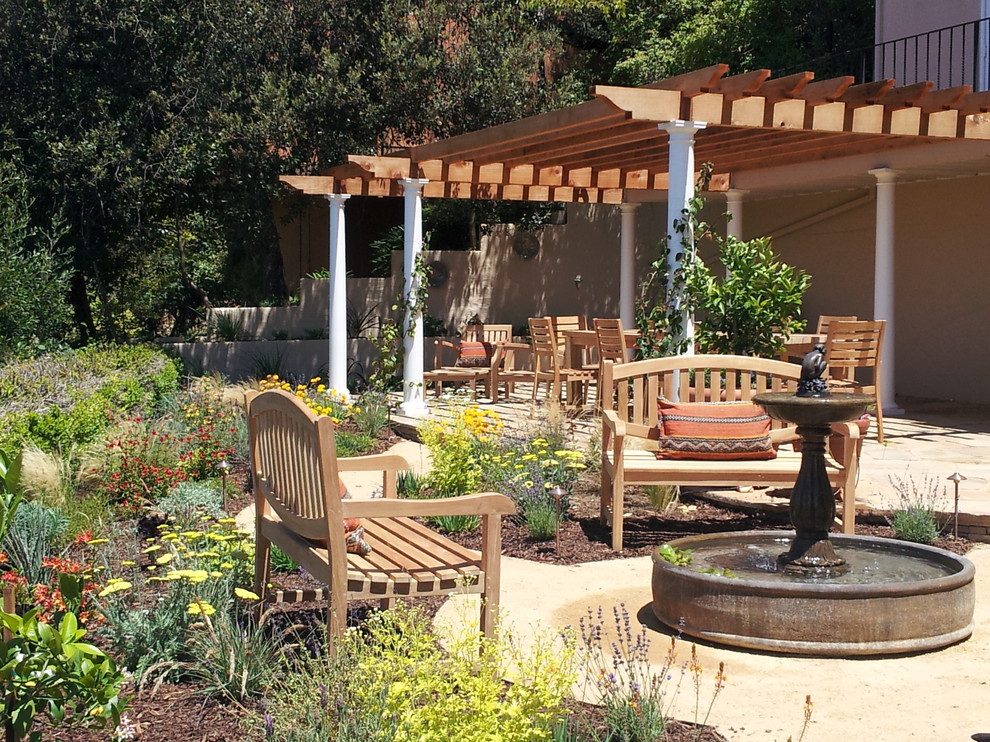 Design ideas for a large mediterranean backyard patio in San Francisco with a water feature, decomposed granite and a pergola.