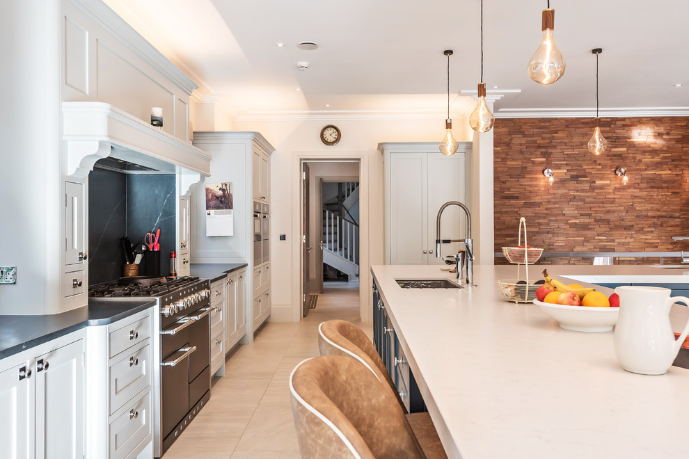 Large traditional l-shaped open plan kitchen in Berkshire with shaker cabinets, grey cabinets, quartzite benchtops, blue splashback, marble splashback, marble floors, with island, beige floor and white benchtop.