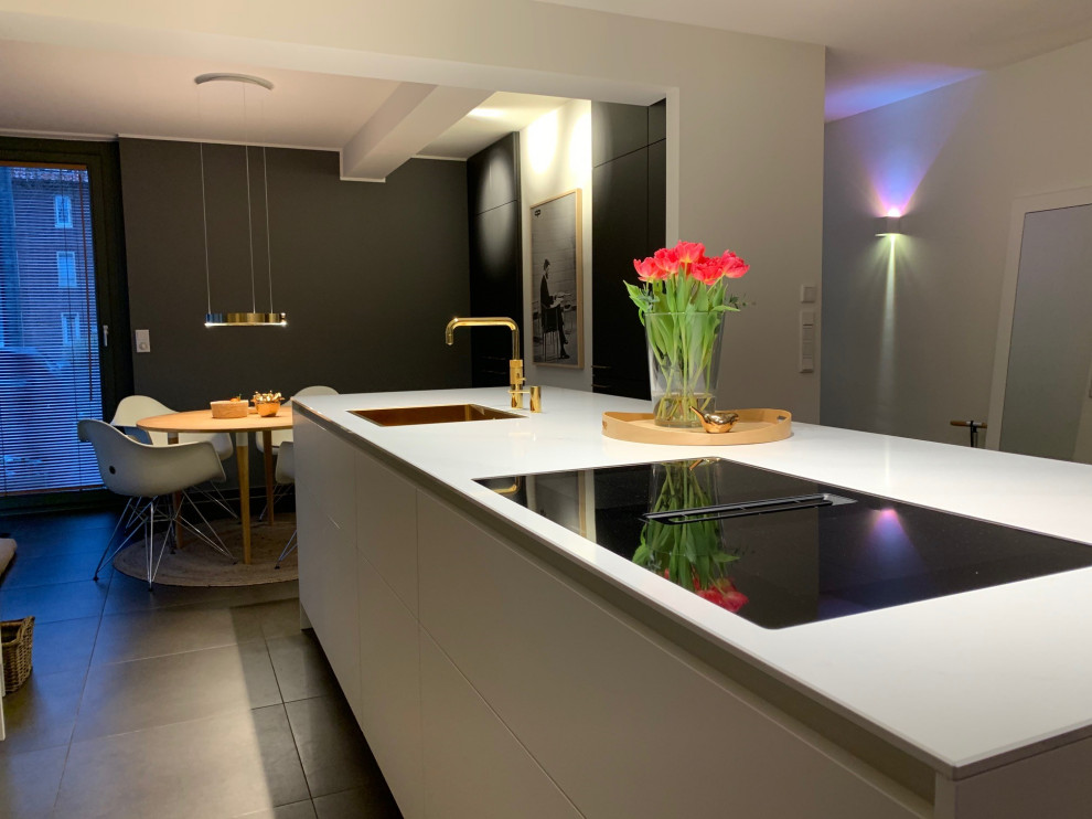 Zweizeilige, Große Moderne Küche mit Quarzwerkstein-Arbeitsplatte, braunem Holzboden und Kücheninsel in Sonstige