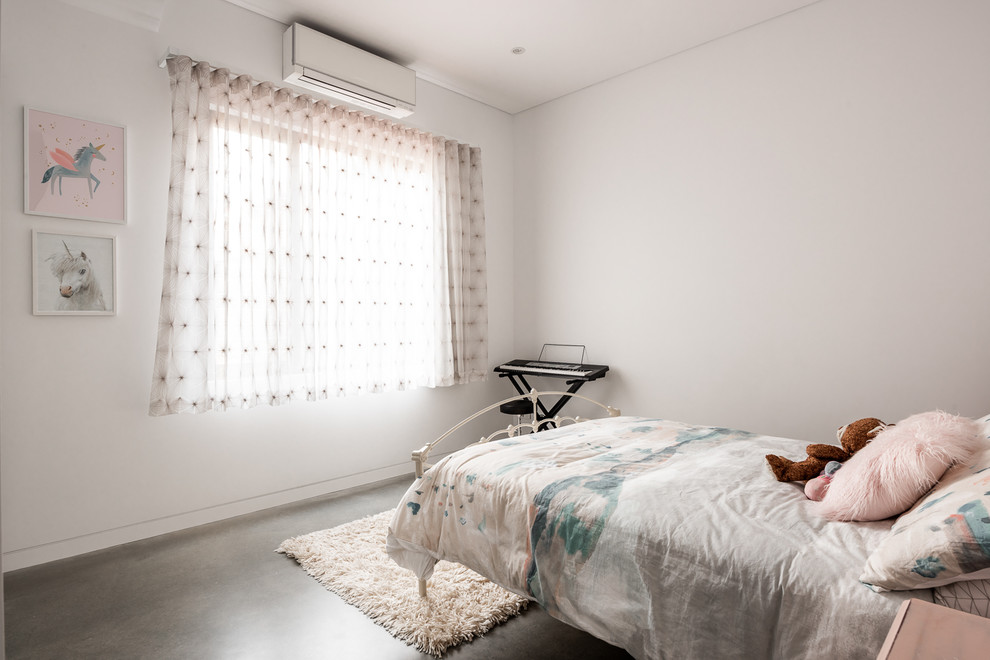 Photo of a mid-sized industrial kids' room for girls in Perth with white walls, concrete floors and grey floor.