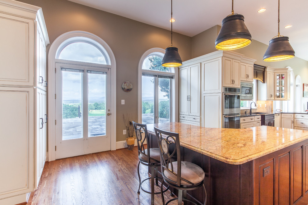 Example of a huge transitional medium tone wood floor eat-in kitchen design in DC Metro with raised-panel cabinets, granite countertops, stainless steel appliances and an island