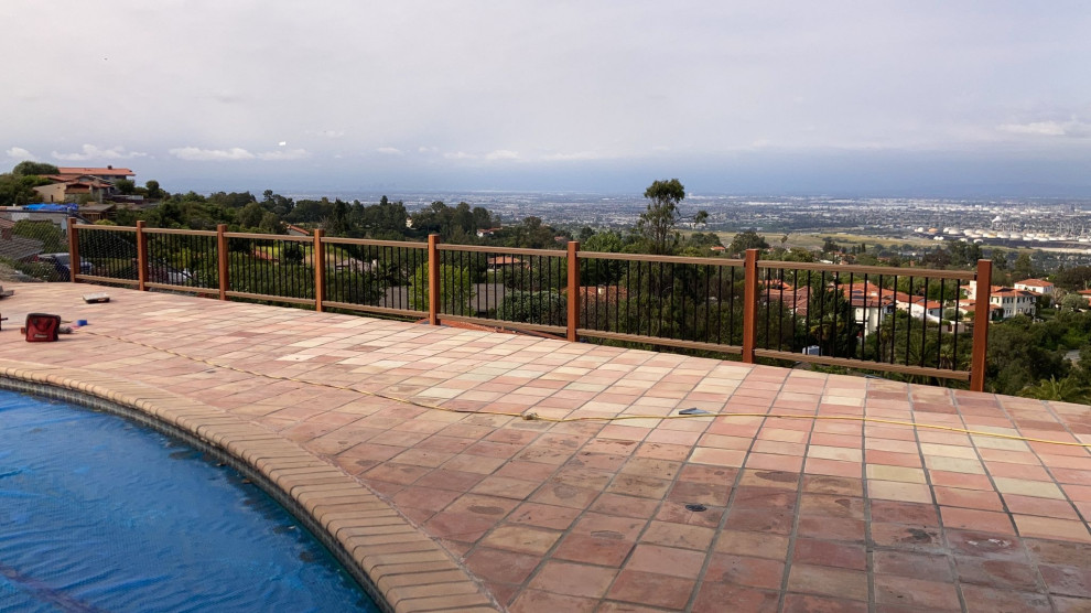 Imagen de piscina elevada mediterránea grande en patio trasero con paisajismo de piscina y suelo de baldosas