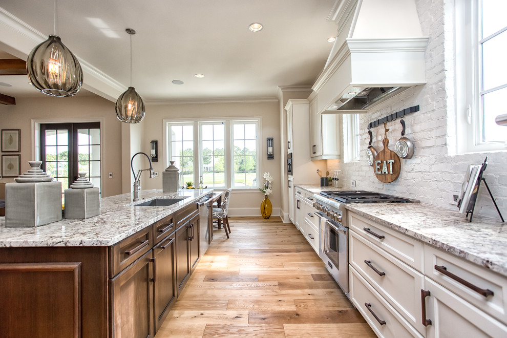 Design ideas for a traditional open plan kitchen in Orange County with an undermount sink, recessed-panel cabinets, white cabinets, stainless steel appliances, with island and medium hardwood floors.