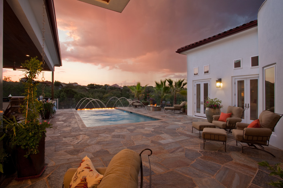 Inspiration for a mid-sized rustic backyard stone and rectangular infinity pool remodel in Austin