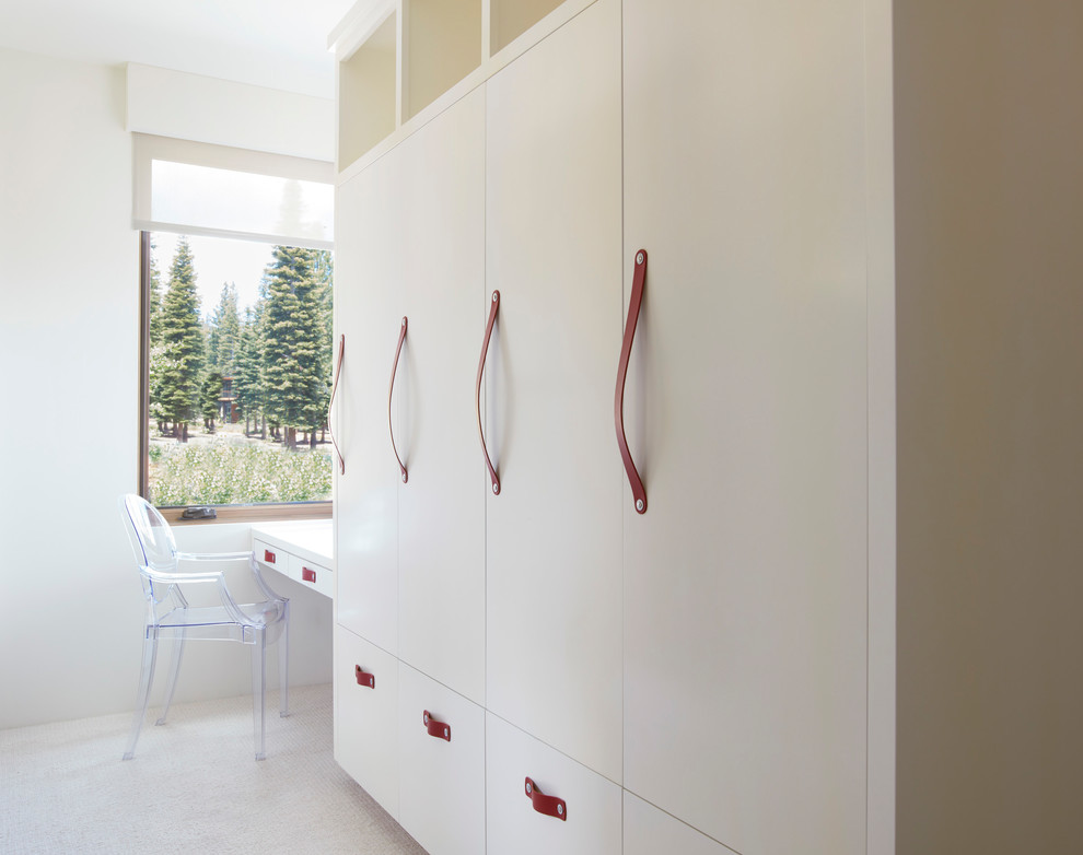 This is an example of a mid-sized transitional gender-neutral kids' bedroom for kids 4-10 years old in San Francisco with carpet, white floor and white walls.