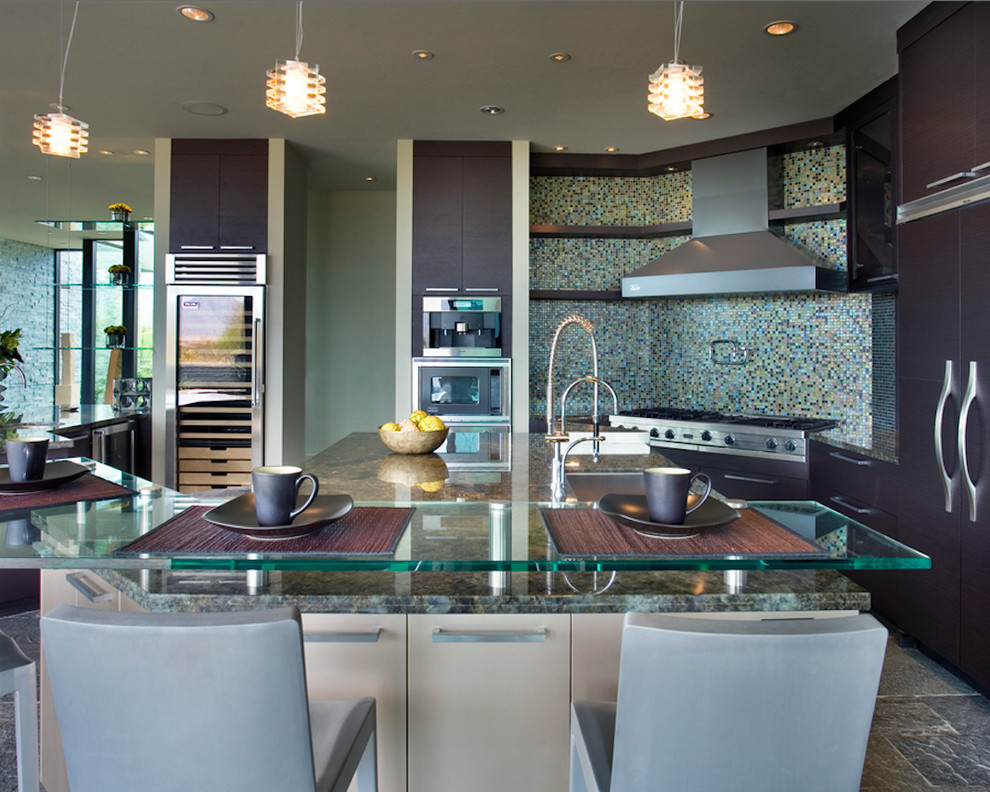 This is an example of a large contemporary u-shaped eat-in kitchen in Phoenix with an undermount sink, flat-panel cabinets, dark wood cabinets, granite benchtops, multi-coloured splashback, mosaic tile splashback, panelled appliances, with island and grey floor.