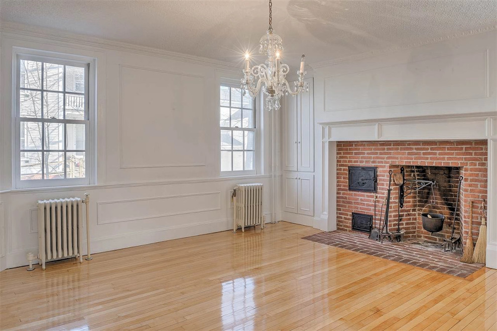 Expansive traditional open plan dining in Boston with grey walls, medium hardwood floors, a standard fireplace, a brick fireplace surround, brown floor and coffered.