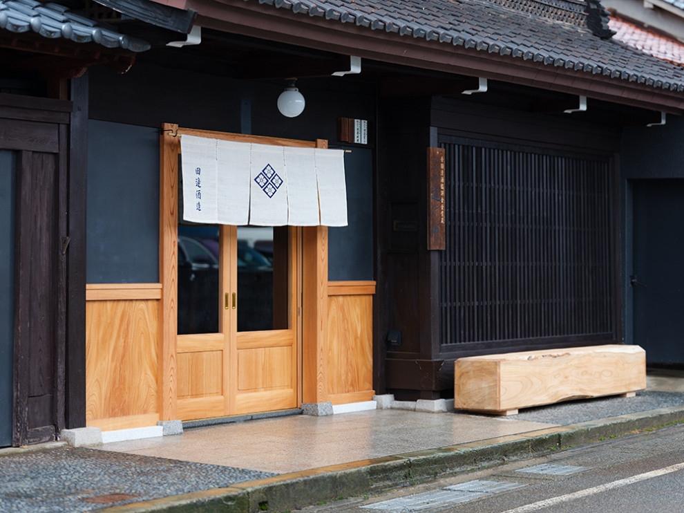 Réalisation d'une entrée asiatique avec un mur noir, sol en granite, une porte coulissante, une porte en bois clair, un sol gris et un plafond en bois.