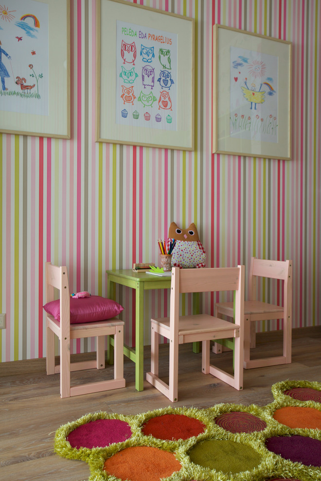 This is an example of an eclectic kids' room for girls with light hardwood floors.