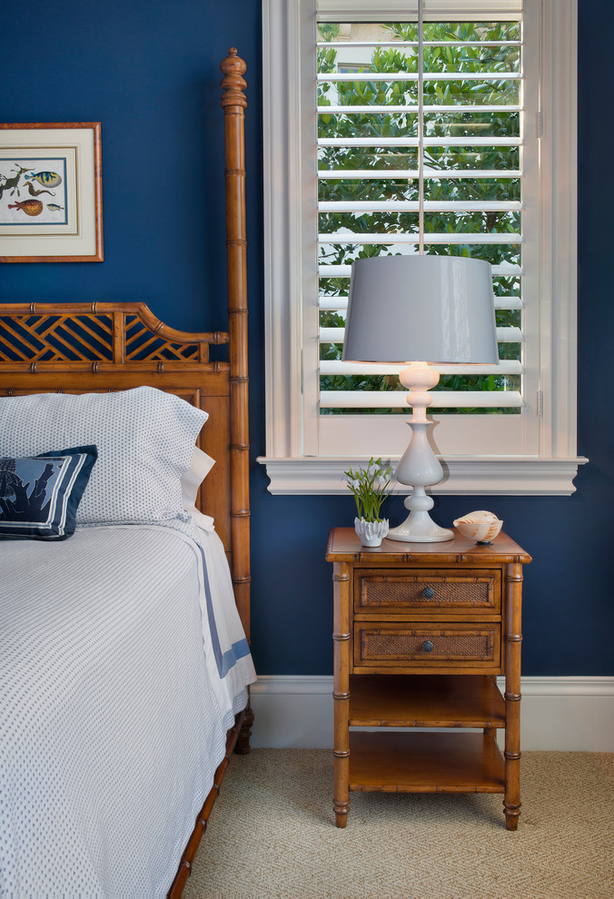 This is an example of a mid-sized tropical guest bedroom in Miami with blue walls, carpet and no fireplace.