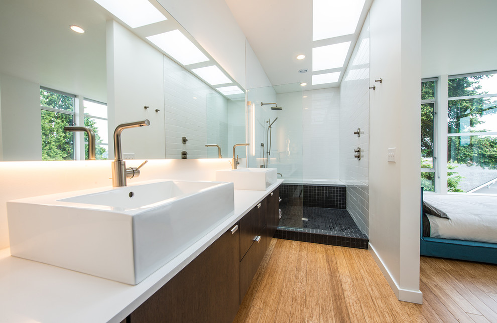 Small minimalist master white tile and subway tile medium tone wood floor drop-in bathtub photo in Seattle with a vessel sink, flat-panel cabinets, dark wood cabinets, white walls, a wall-mount toilet and quartz countertops