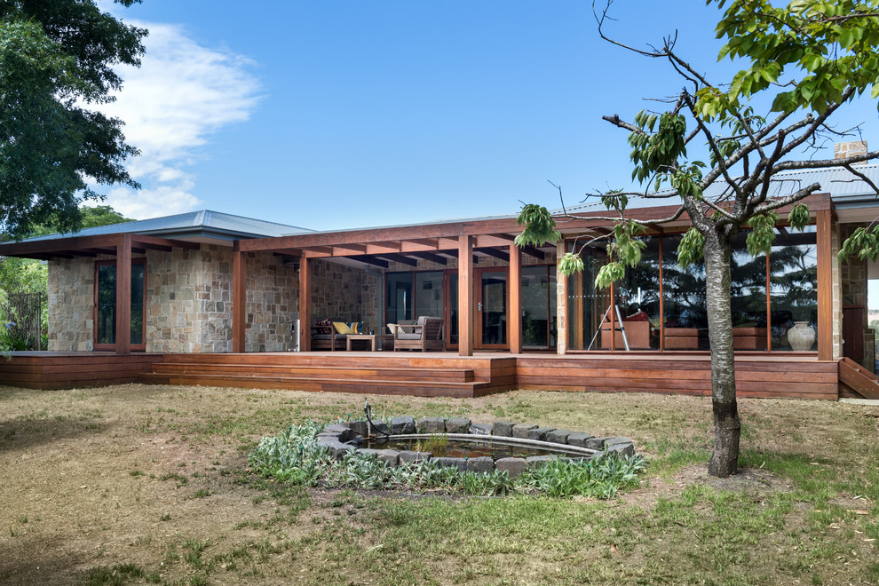 This is an example of a country front yard verandah in Other with decking and a roof extension.