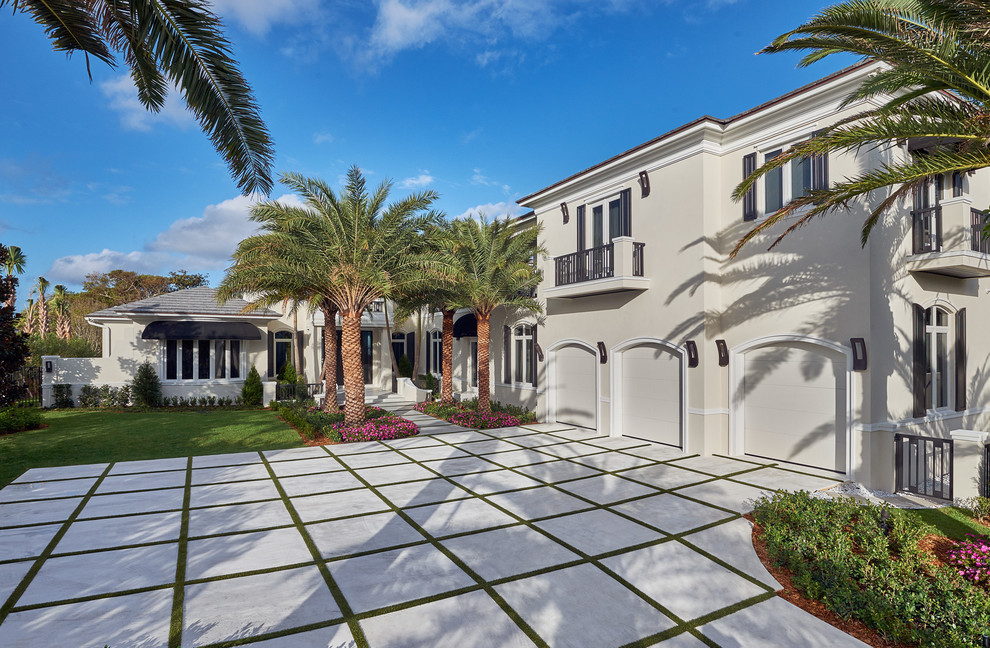 Photo of an expansive tropical attached three-car garage in Miami.