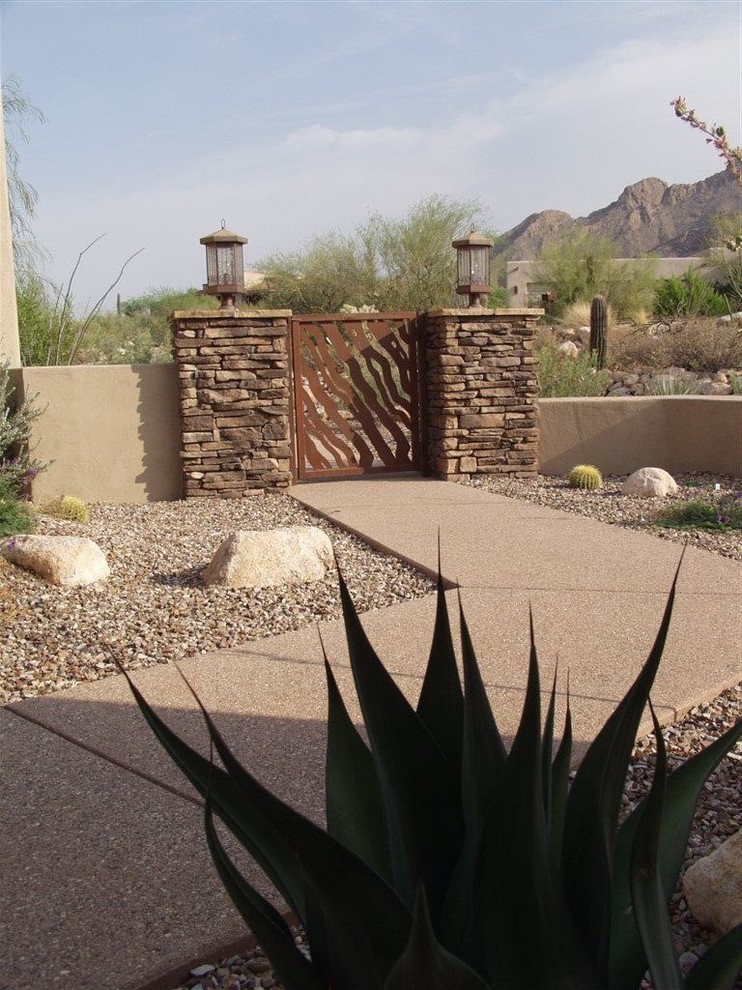 Mid-sized tuscan concrete floor and gray floor front door photo in Phoenix with brown walls and a medium wood front door