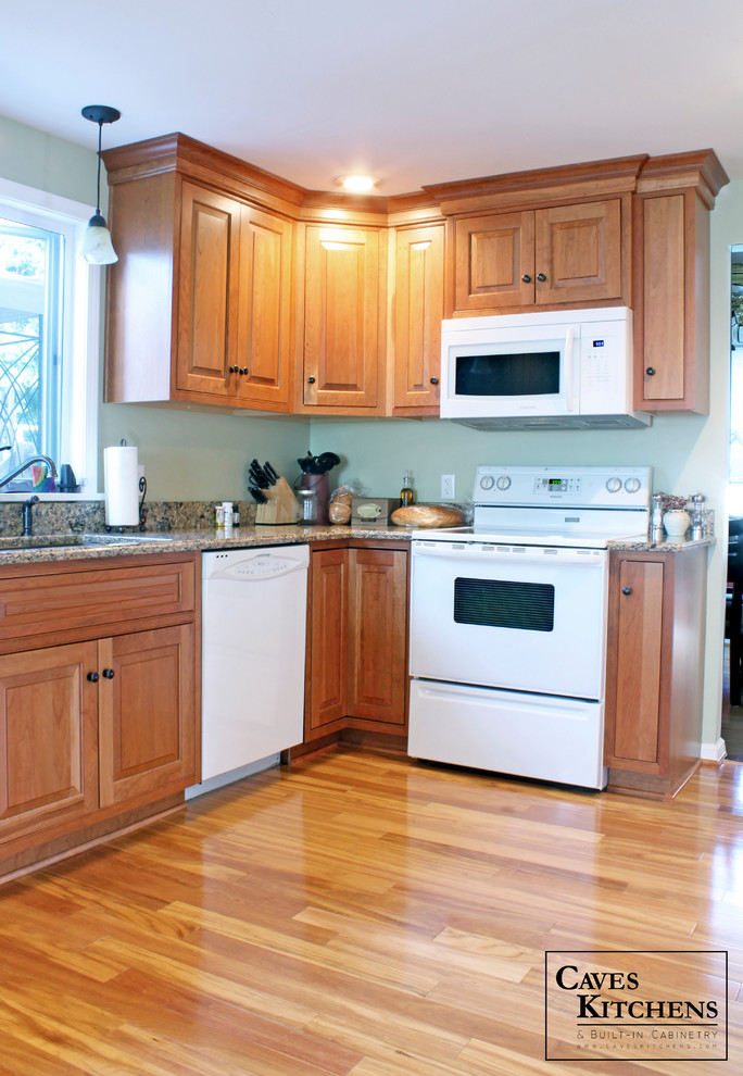 Example of a mid-sized transitional u-shaped medium tone wood floor eat-in kitchen design in New York with an undermount sink, beaded inset cabinets, medium tone wood cabinets, quartz countertops, multicolored backsplash, stone slab backsplash, white appliances, green walls and a peninsula