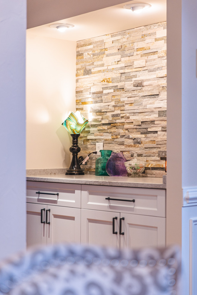 Example of a mid-sized transitional eat-in kitchen design in DC Metro with shaker cabinets, white cabinets, granite countertops, multicolored backsplash, stone tile backsplash and gray countertops