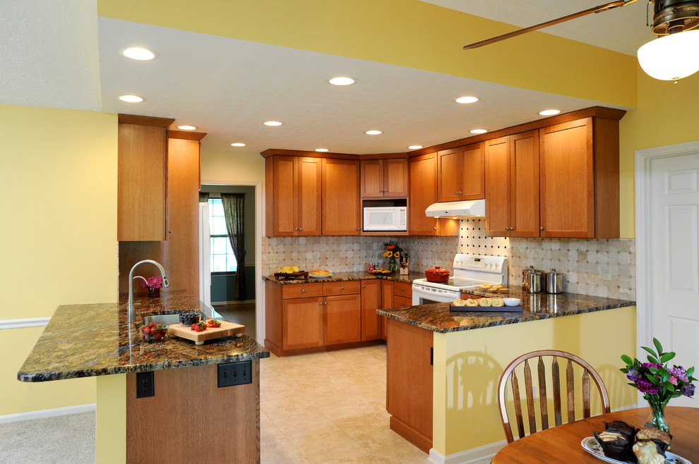 Example of a mid-sized transitional u-shaped limestone floor and beige floor eat-in kitchen design in Cincinnati with a double-bowl sink, shaker cabinets, medium tone wood cabinets, granite countertops, beige backsplash, ceramic backsplash, stainless steel appliances and a peninsula
