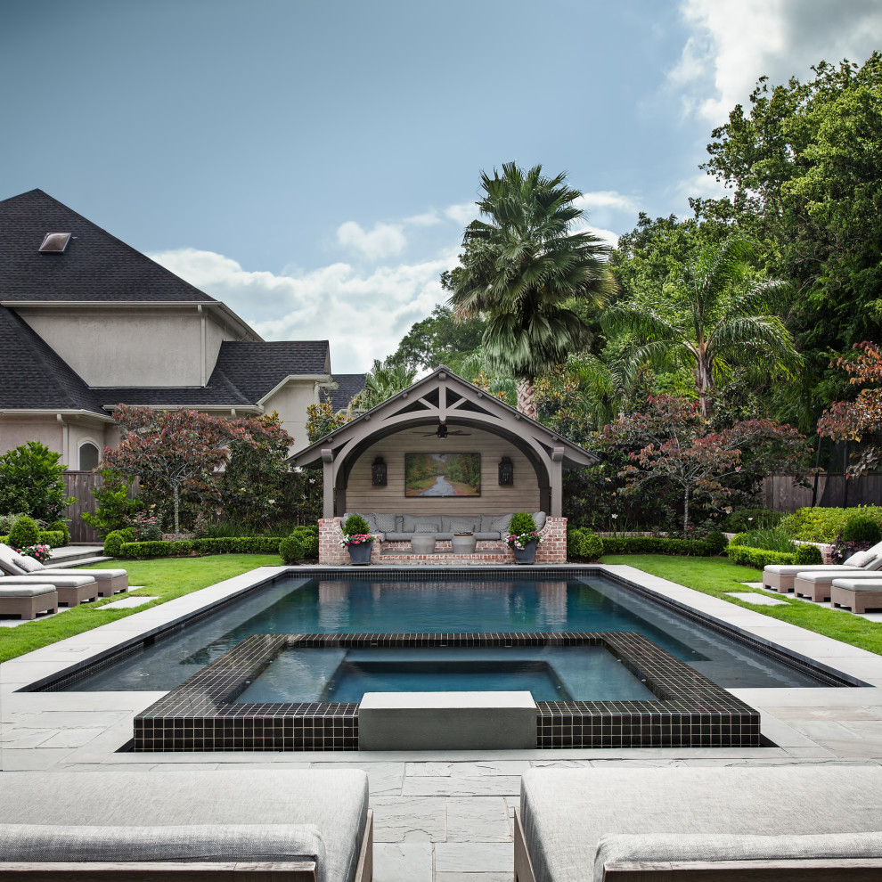 Photo of a mid-sized transitional backyard rectangular lap pool in Houston with a hot tub and natural stone pavers.