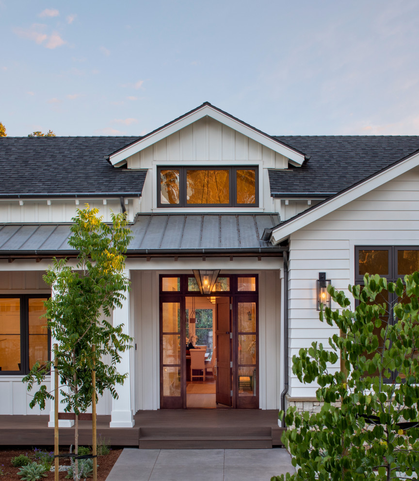 Photo of a country front door in San Francisco with white walls, dark hardwood floors, a single front door, a medium wood front door, brown floor and exposed beam.