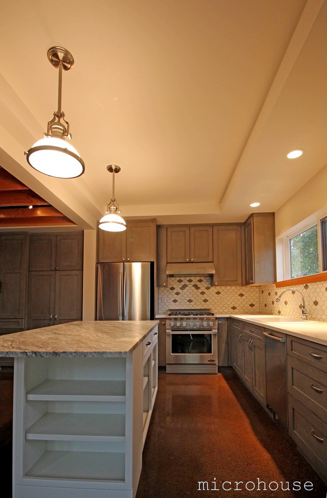 Open concept kitchen - small transitional l-shaped concrete floor open concept kitchen idea in Seattle with an undermount sink, medium tone wood cabinets, marble countertops, white backsplash, ceramic backsplash, stainless steel appliances and an island