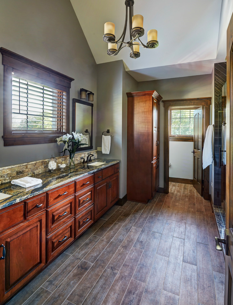 Large country bathroom in Chicago with shaker cabinets, dark wood cabinets, green tile, dark hardwood floors, an undermount sink and granite benchtops.