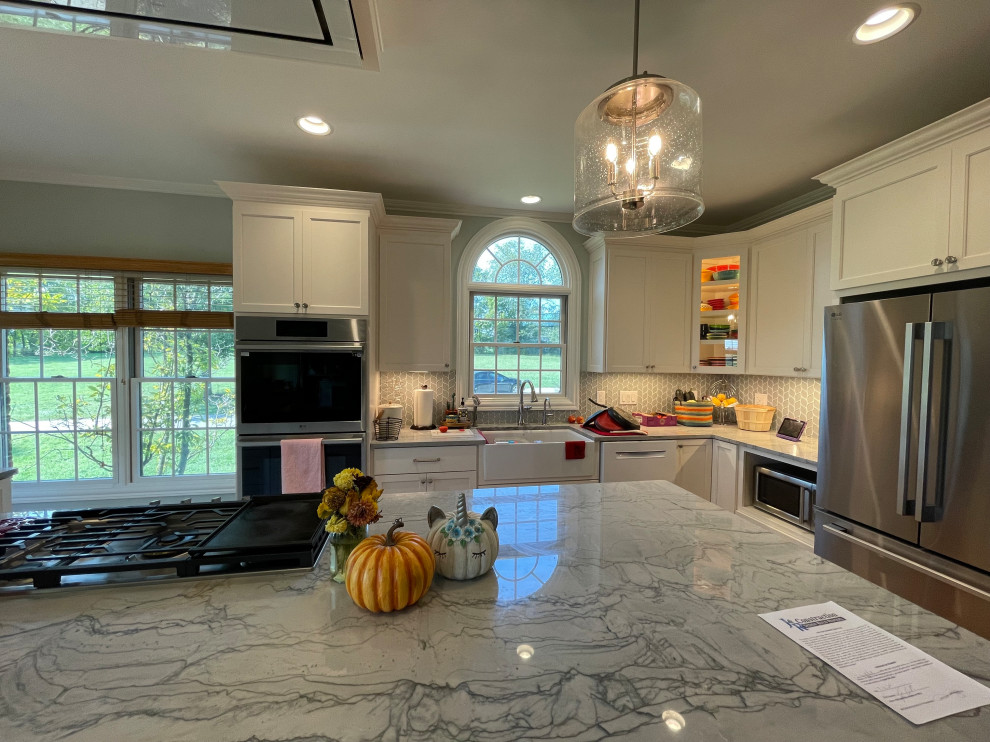 Eat-in kitchen - large transitional light wood floor and brown floor eat-in kitchen idea with an undermount sink, shaker cabinets, white cabinets, quartzite countertops, green backsplash, marble backsplash, stainless steel appliances, an island and gray countertops