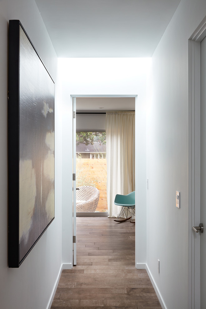 Design ideas for a midcentury hallway in San Francisco with white walls, medium hardwood floors and beige floor.