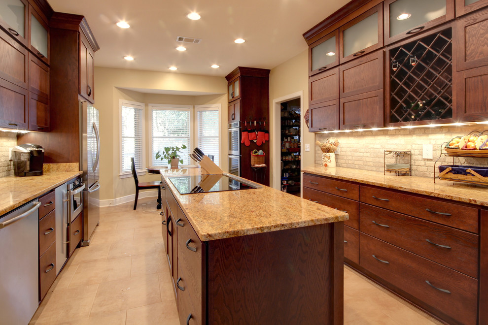 Eat-in kitchen - transitional eat-in kitchen idea in Miami with an undermount sink, shaker cabinets, brown cabinets, granite countertops, beige backsplash, stone tile backsplash and stainless steel appliances