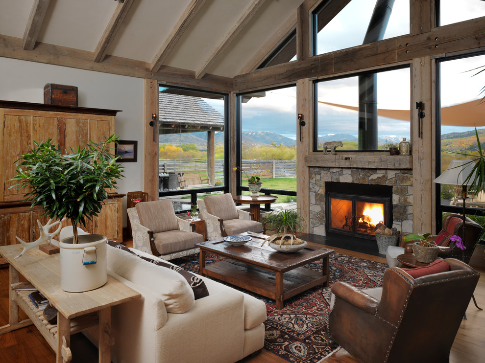 Inspiration for a mid-sized country open concept living room in Other with white walls, medium hardwood floors, a standard fireplace and a stone fireplace surround.
