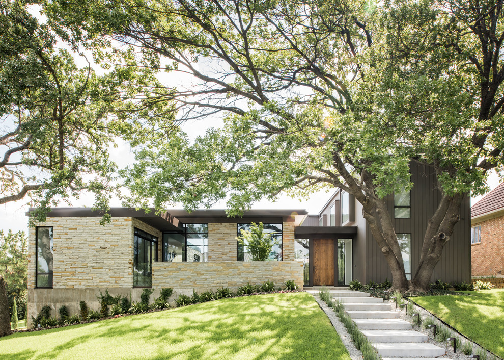 Modern two-storey exterior in Dallas with stone veneer and a flat roof.