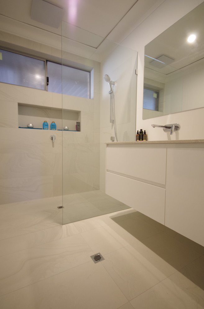 Photo of a contemporary master bathroom in Perth with furniture-like cabinets, white cabinets, an open shower, white tile, porcelain tile, white walls, porcelain floors, an undermount sink, engineered quartz benchtops, yellow floor, an open shower and white benchtops.